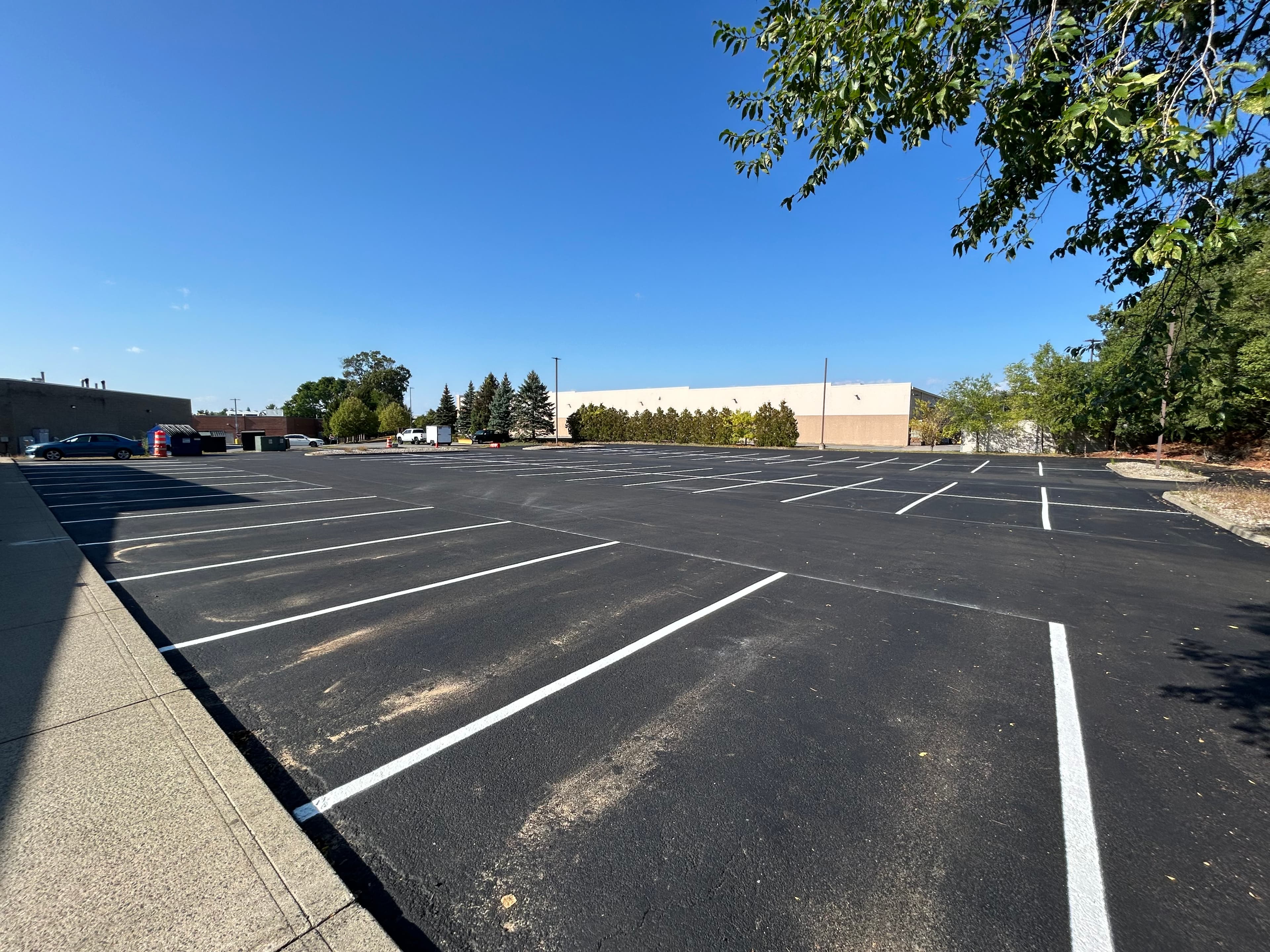 Back lot of commercial plaza after restriping over sealcoat